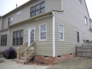 Beige two-story house exterior with back steps