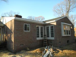 Brick house addition under construction with ladder