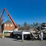 Concrete pump truck pouring foundation in neighborhood