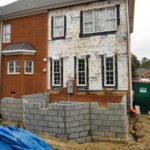 Brick house renovation with cinderblock retaining wall