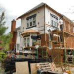 Brick house renovation with scaffolding and workers