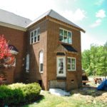 Two-story brick house exterior under renovation