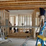 Home interior framing with workers and ladders