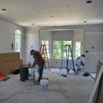 Room under renovation with workers and ladders