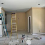 Interior room renovation with ladders and painter