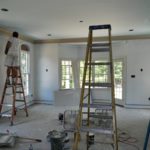 Painters on ladders painting a living room