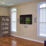 Living room with wall-mounted TV and windows