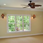Empty room with large window and ceiling fan