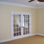 Empty beige room with white French doors