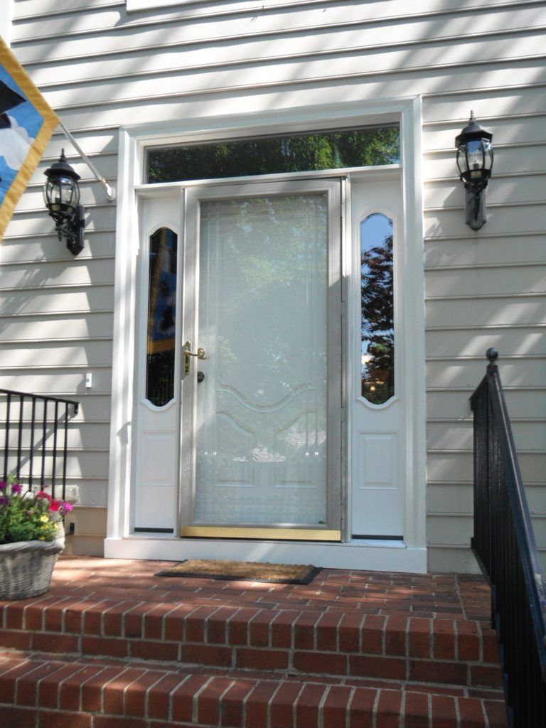 White front door with sidelights and lanterns