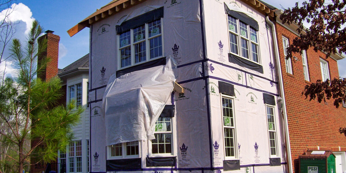 Two-story house addition wrapped in weather barrier